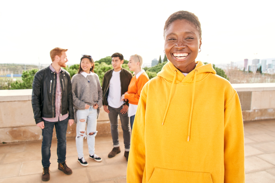 Portrait of a black girl standing up looking at the camera. Yellow