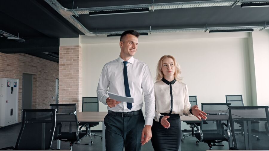 Male and a female walking in a corporate office